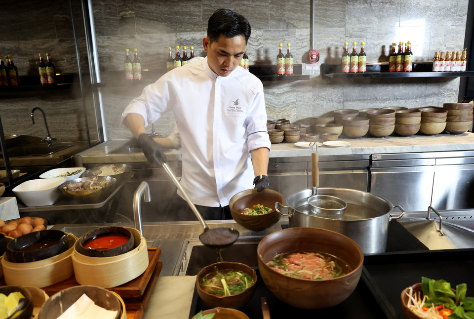 A chef prepares the "choc troi" (sky-high) pho and stir-fried pho combo (Pho Landmark81). (Photo: VNA)