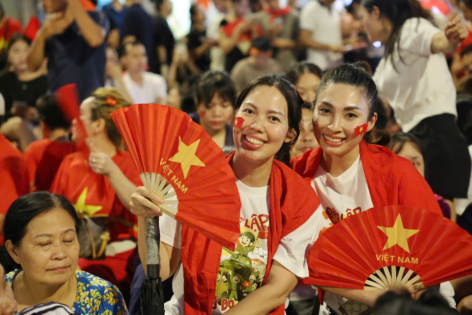 People wait to welcome the parade contingents at the Cua Nam intersection. (Photo: VNA)