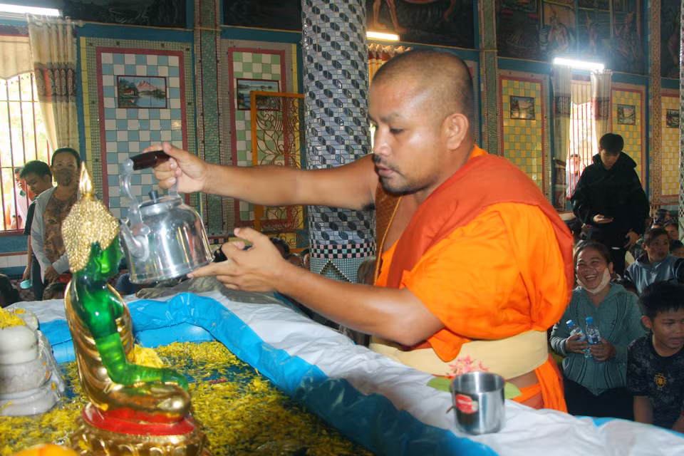 A monk performs the ritual of bathing the Buddha. (Photo: VNA)