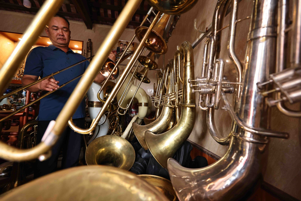 Nguyen Van Huong, a local resident, checks a brass instrument. (Photo: Minh Duc)