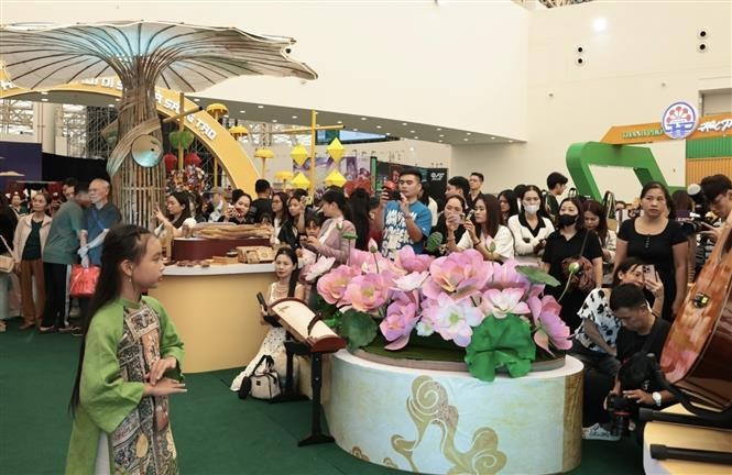 A large crowd gathers to watch children model ao dai costumes. (Photo: VNA)