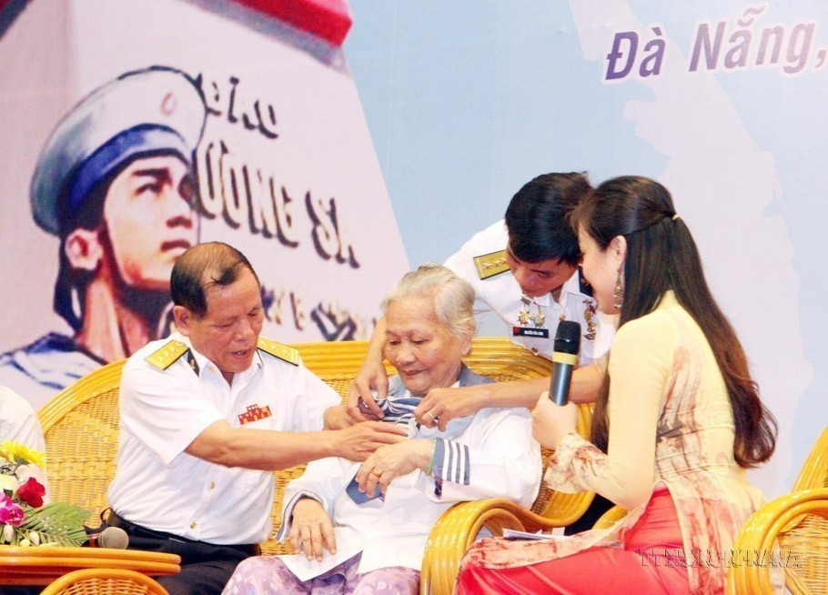 Le Thi Muon, mother of martyr Phan Van Su, who bravely sacrificed his life in the battle to defend Gac Ma in 1988, wears the only remaining keepsake of her son – his shirt – during the “Towards Beloved Truong Sa” programme on March 14, 2013. (Photo: VNA)