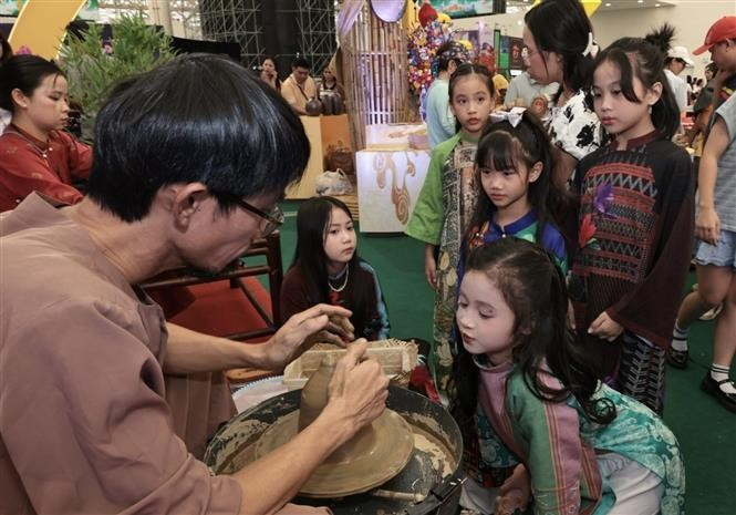 A child enjoys exploring ceramic products from Hue. (Photo: VNA)