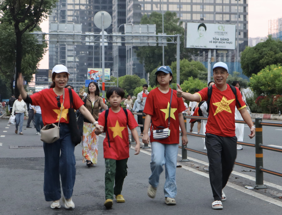 An entire family eagerly attending the full dress rehearsal for the parade celebrating the 50th anniversary of the Liberation of the South and National Reunification. (Photo: VNA)