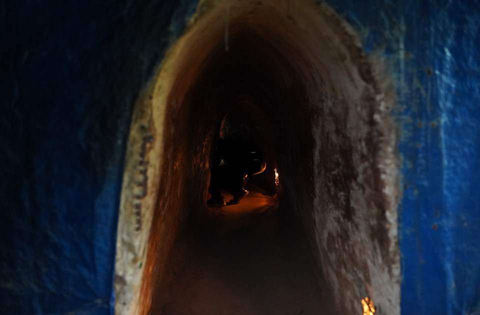 Visitors must crouch low to navigate the dark, narrow spaces within the tunnels. (Photo: VNA)