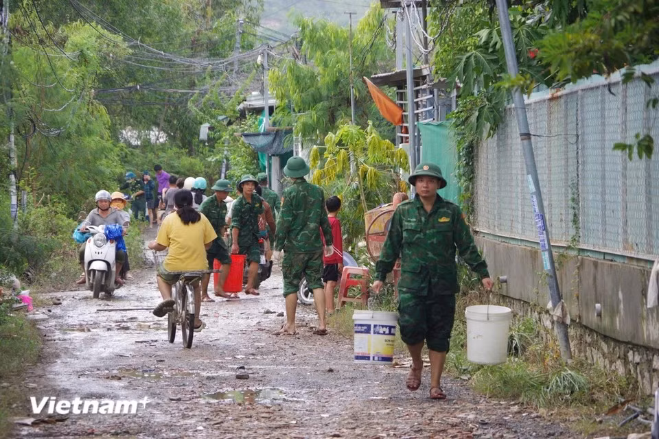 Nha Trang Port Border Guard Station works with local forces to clear mud, collect debris and unclog drainage systems following the floods. (Photo: Vietnam+)