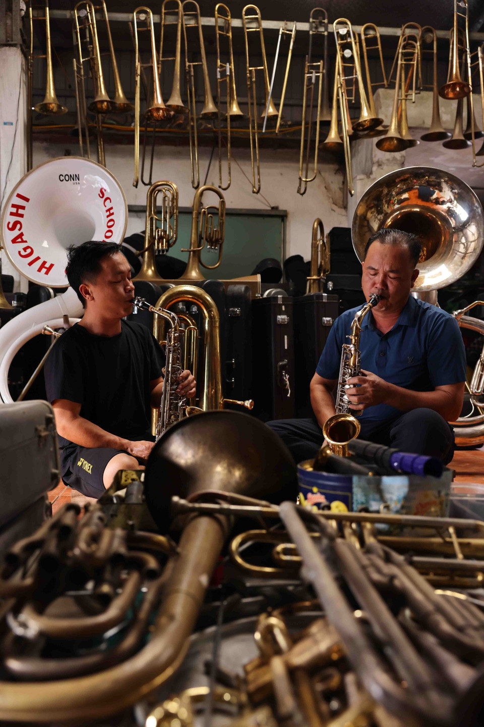 Nguyen Van Huong and his son inspect a brass instrument before returning it to their client. (Photo: Minh Duc)