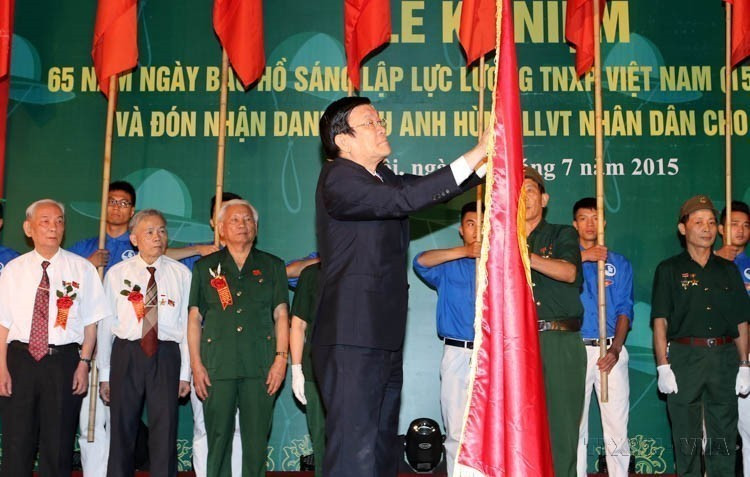 President Truong Tan Sang presents the title of Hero of the People’s Armed Forces to Team 36 of the Youth Volunteers at the ceremony marking the 65th anniversary of the founding of the Vietnamese Youth Volunteers by President Ho Chi Minh (July 15, 1950 – July 15, 2015). (Photo: VNA)