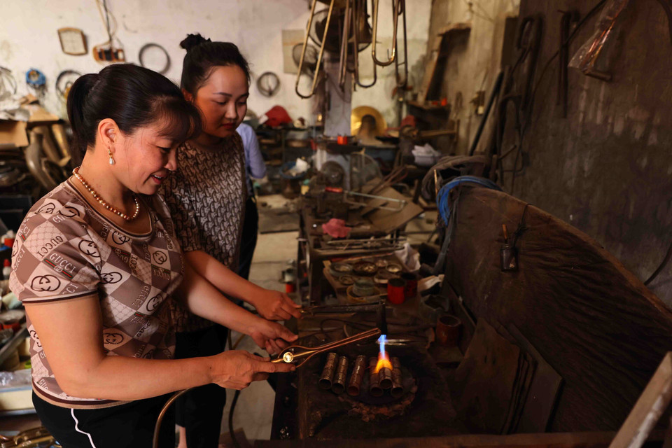 Nguyen Van Huong’s wife and daughter handle the intricate soldering processes. (Photo: VNA)