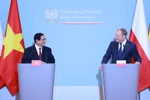 Prime Minister Pham Minh Chinh (L) and his Polish counterpart Donald Tusk at the joint press conference in Warsaw on January 16. (Photo: VNA)