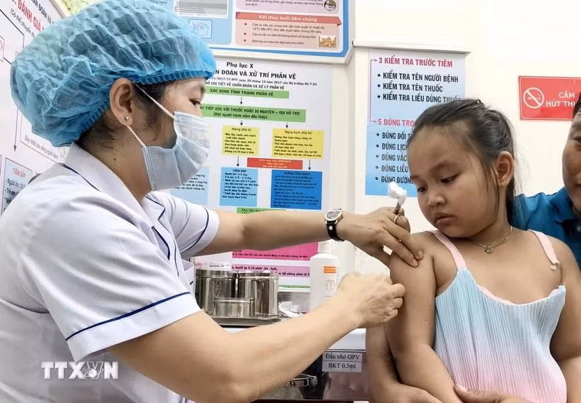A kid gets measles jab at An Lac ward medical station in Binh Tan district. (Photo: VNA)