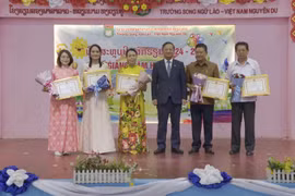 Vietnamese Ambassador to Laos Nguyen Minh Tam presents certificates of merit to the Vietnamese community in Vientiane and leaders of the Nguyen Du Lao-Vietnamese bilingual school for their contributions to preserving Vietnamese culture. (Photo: VNA)