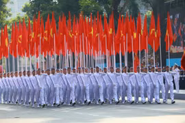 The procession of the Party and national flags passes by the grandstand. (Photo: VNA)