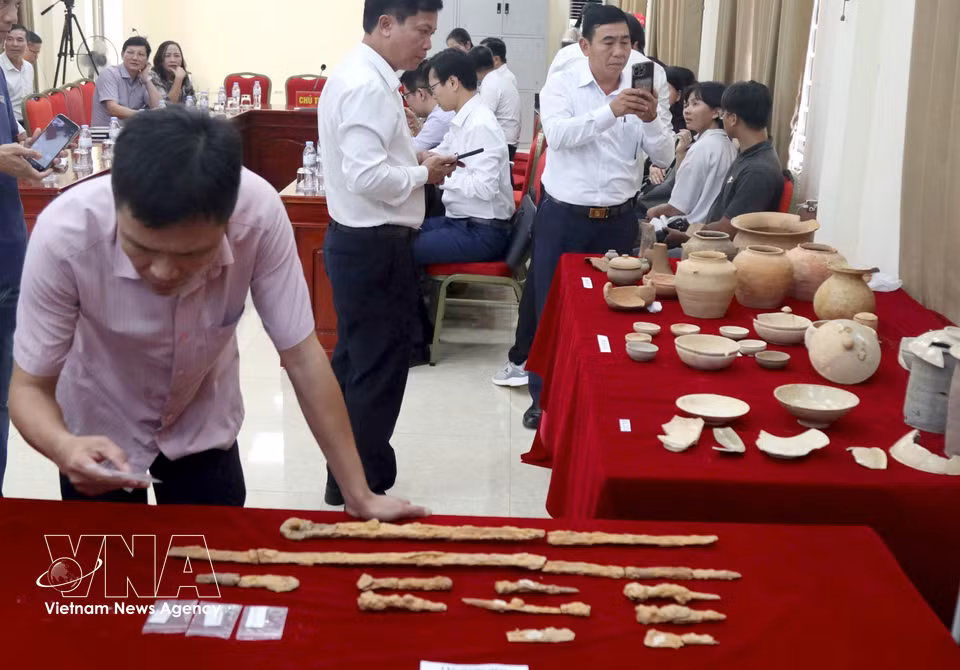 A large number of burial objects are unearthed, including ceramic and stoneware jars, cups, bowls, pots and bottles; Wu Zhu coins; iron knives, sabres and swords; bronze objects; glass beads; and yellow-coloured metal beads and sheets. (Photo: Van Ty/VNA)