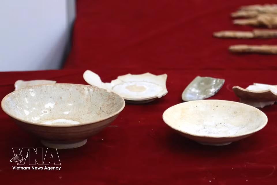 A large number of burial objects are unearthed, including ceramic and stoneware jars, cups, bowls, pots and bottles; Wu Zhu coins; iron knives, sabres and swords; bronze objects; glass beads; and yellow-coloured metal beads and sheets. (Photo: Van Ty/VNA)