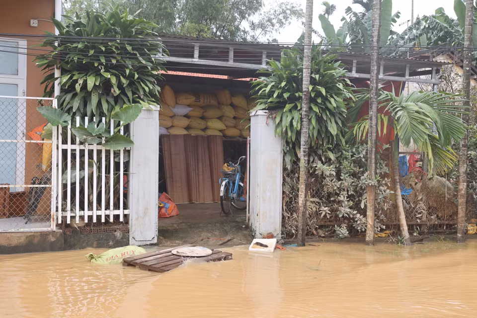 Residents raise their belongings to escape a second round of flooding. (Photo: VNA)