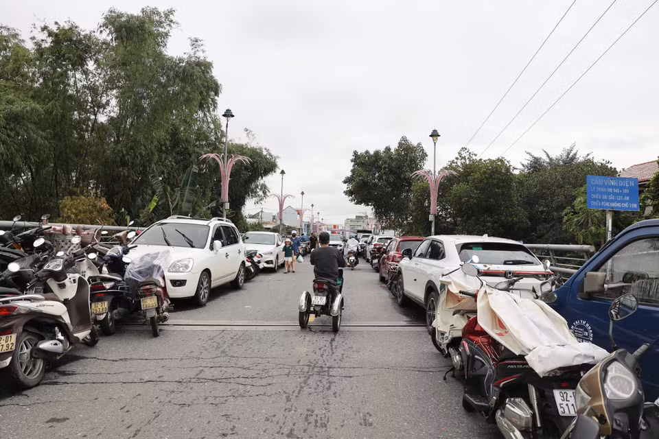 Cars and motorbikes are moved onto Vinh Dien Bridge to avoid flooding. (Photo: VNA)