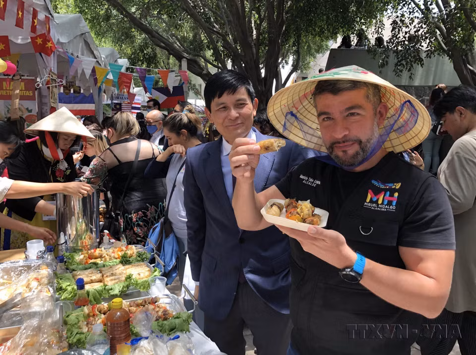 Miguel Hidalgo district's mayor Mauricio Tabe Echartea enjoys Vietnamese fried spring rolls at the ASEAN+3 Bazaar in Mexico, marking ASEAN’s 55th anniversary (August 8, 2022). (Photo: VNA)