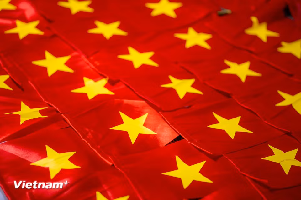 National flags, made with skill and care, help brighten the country in the vibrant red of the festive season. (Photo: Vietnam+)