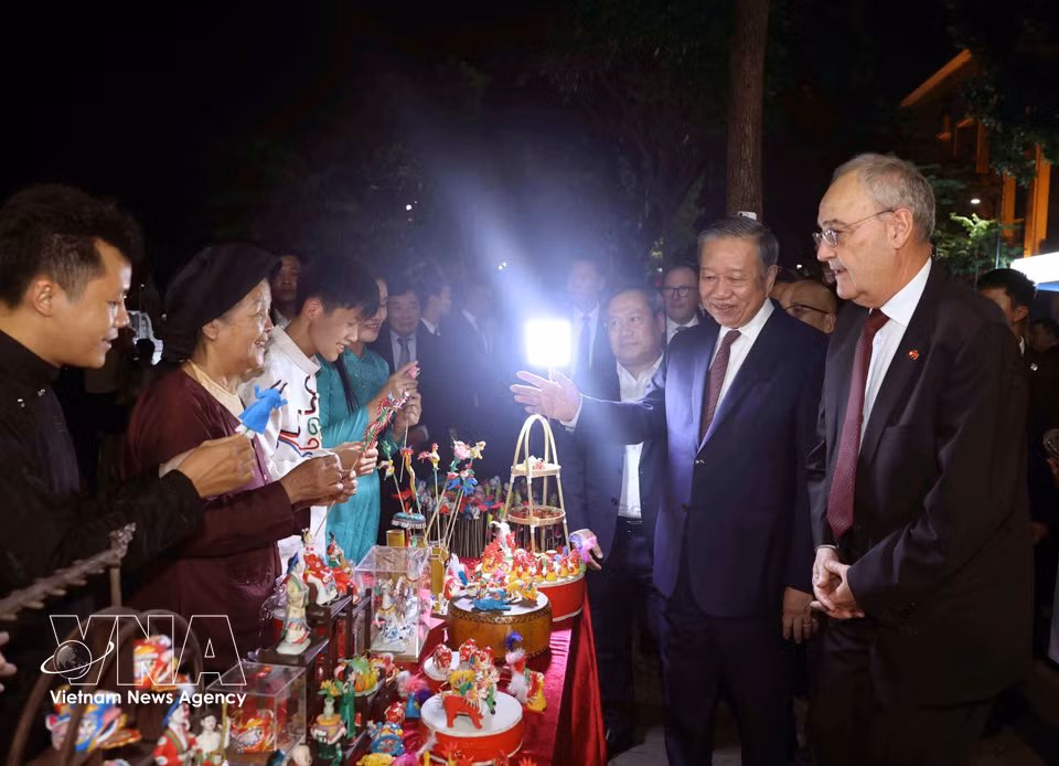 Party General Secretary and State President To Lam introduces Swiss President Guy Parmelin to the traditional folk art of to he figurine-making at the pedestrian area. (Photo: Thong Nhat/VNA)