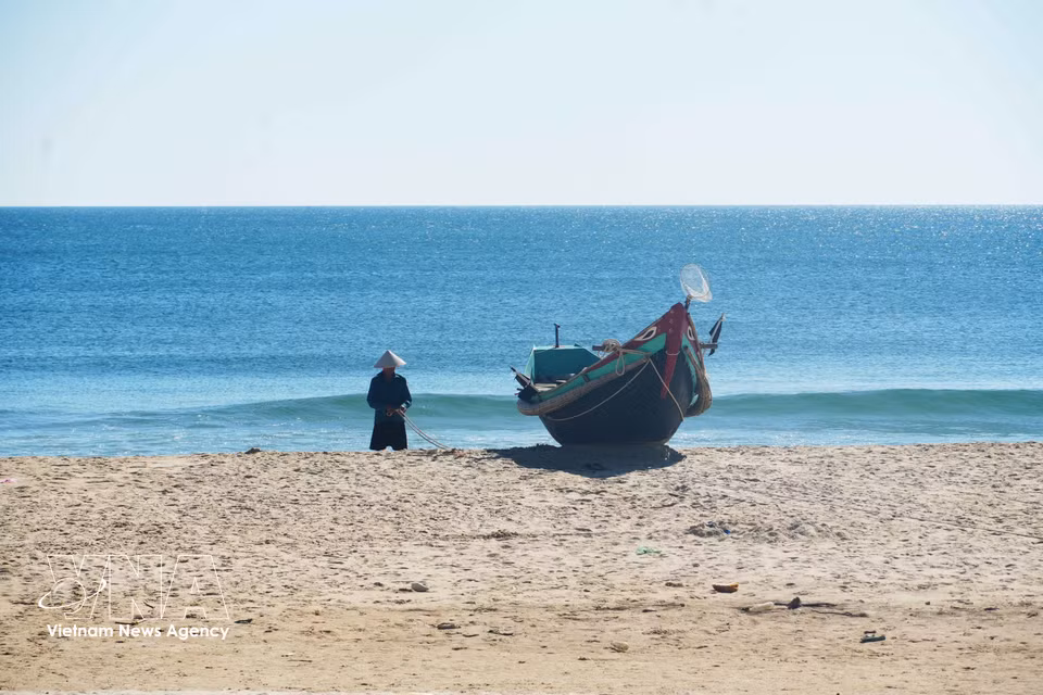 A fisherman works in the peaceful surroundings of Ben Hai beach in Quang Tri province. (Photo: Tuong Vi/VNA)