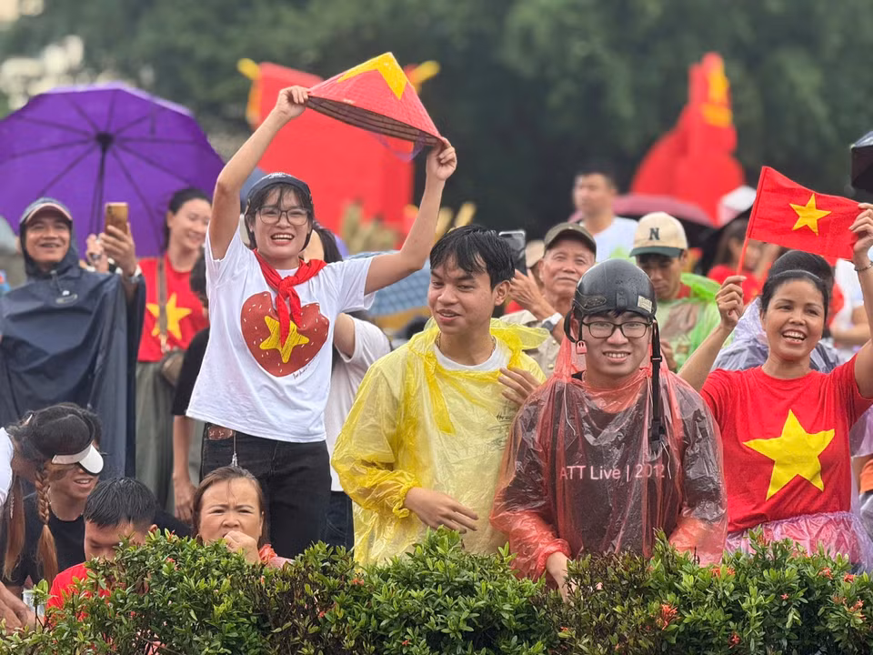 Love and pride outweigh the rain. A moment capturing Hanoians enduring the weather, patiently waiting and cheering for the armed forces. (Photo: VNA)