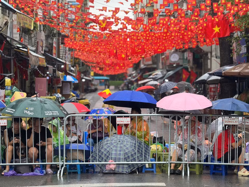 Hanoians endure the weather, patiently waiting and cheering for the armed forces. (Photo: VNA)
