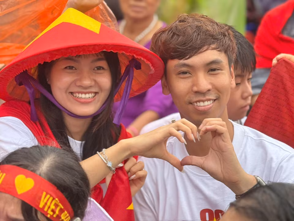 Love and pride outweigh the rain. A moment capturing Hanoians enduring the weather, patiently waiting and cheering for the armed forces. (Photo: VNA)