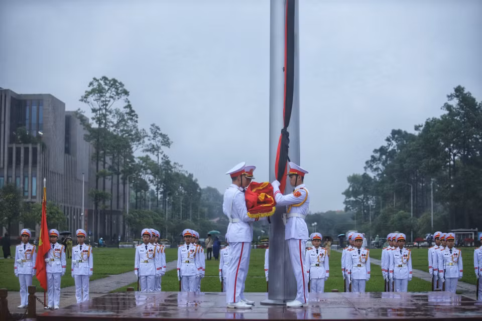 Honour guards perform the flag-lowering ceremony for the state funeral of former President Tran Duc Luong. (Photo: VNA)