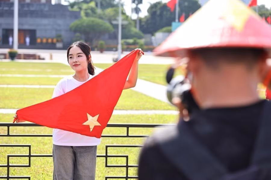 The red flag with a yellow star is an indispensable prop in these festive photographs. (Photos: VNA)