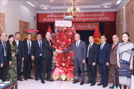 Permanent Deputy Secretary of the Ho Chi Minh City Party Committee Nguyen Ho Hai (left) presents a bouquet to Deputy Consul General of Laos in the city Amphay Souvannaseng. (Photo: VNA)