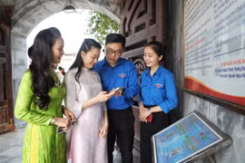 Youth Union members guide tourists to scan QR codes to learn about the Xuong Giang Victory historical site. (Photo: VNA)
