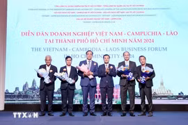 Vice Chairman of the Ho Chi Minh City People's Committee Bui Xuan Cuong (3rd from right) gives flowers to representatives of the forum organising board. (Photo: VNA)