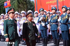 Vietnamese Minister of National Defence Gen. Phan Van Giang (left) and his Lao counterpart Gen. Chansamone Chanyalath inspect the guard of honour at the second Vietnam-Lao border defence friendship exchange on October 22. (Photo: VNA)