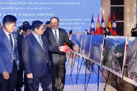 PMs of Vietnam, Laos visit photo exhibition on achievements of economic ties