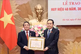NA Chairman Tran Thanh Man (right) presents the 40-year Party membership badge to Nguyen Duc Hai, member of the Party Central Committee and Vice Chairman of the legislature, on June 7. (Photo: VNA)