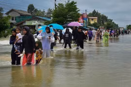 People wade through flood water in Narathiwat province of Thailand. (Photo: Getty Images/VNA)