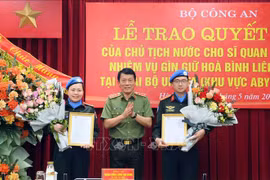 Deputy Minister of Public Security Sen. Lt. Gen. Luong Tam Quang (centre) presents the State President's decisions to the two officers on May 29. (Photo: VNA)