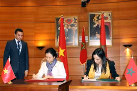 Nguyen Phuong Nga and Mbarka Bouiada sign a meeting minute (Photo: VNA)