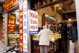 Customers look at gold jewelry on Hang Bac Street, Hanoi (Photo: VNA)