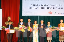 Disadvantaged Lao students received scholarships. (Photo: VNA)