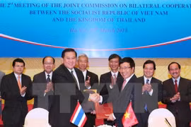 Deputy Prime Minister and Foreign Minister Pham Binh Minh and his Thai counterpart Thanasak Patimapragorn sign the meeting's minute (Source: VNA)