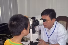 A doctor gives eye check-up to a boy (Photo: VNA)