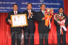 On behalf of Vietnamese President Truong Tan Sang, Chairman Nguyen Manh Hien (second from left) presents Vietnam's Independence Order (second class) to Vientiane authorities and people (Photo: VNA)