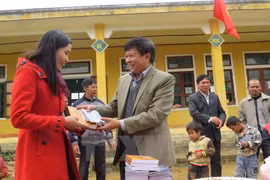 VNA Deputy General Director Dinh Dang Quang presents books to students and teachers in Ngan Thuy commune (Photo: VNA)