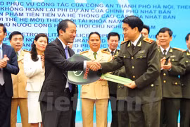 First Secretary Atsuki Tomoyose present the hybrid cars' symbolic key to Major General Nguyen Duc Chung. Source: VNA