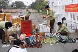 Staff from Da Nang's Market Watchdog Department destroy counterfeit goods (Photo: VNA)