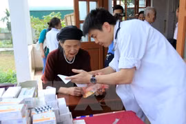 A medical worker gives advice to an elderly (Photo: VNA)
