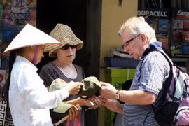 A foreign tourist buys souvenirs in Hanoi's streets. (Source: VNA)