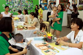 A nutrition expert (R) gives advice to a mother (Photo: VNA)